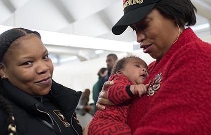 Mayor Bowser holding a baby at Families First event